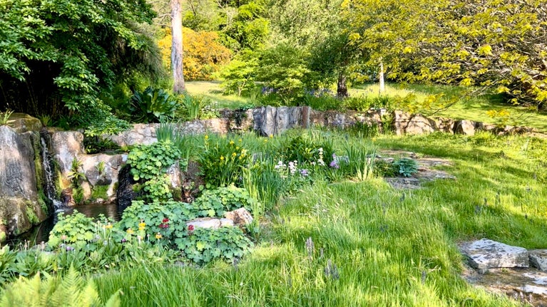 Water falls down the stones in the Gavin Jones Cascade in the garden at Chartwell, Kent